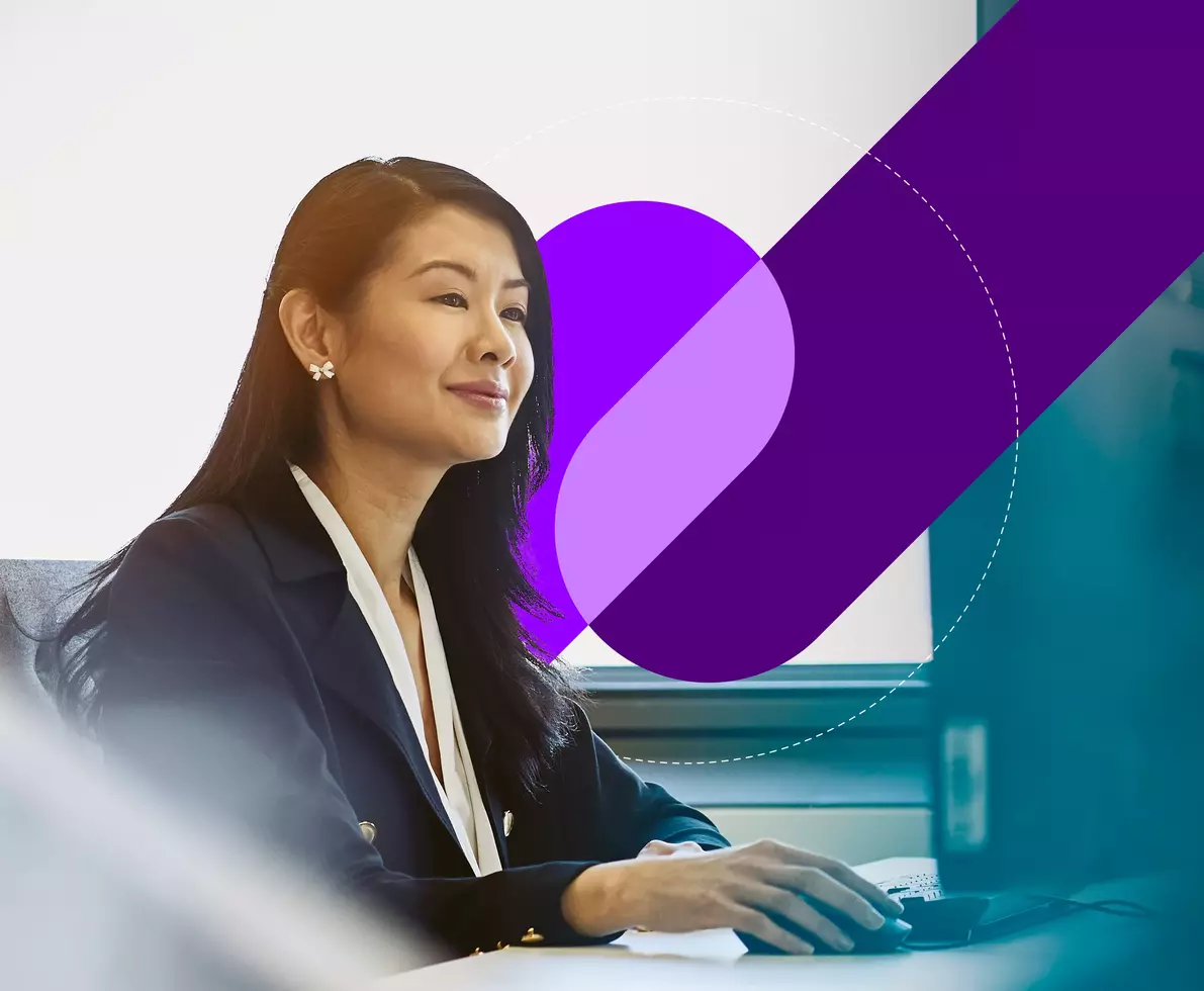 smiling woman in black suit at work on desktop computer