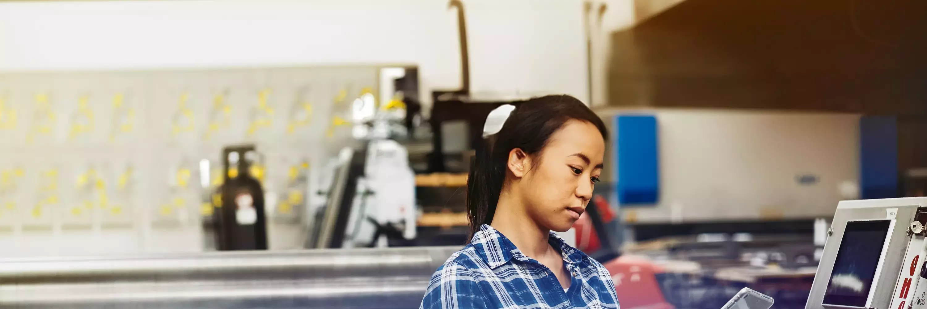 woman inputting into a tablet to operate machinery  